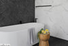 Elegant-bathroom-with-a-black-and-white-marble-wall-and-cozy-candle-pots-on-a-wooden-table