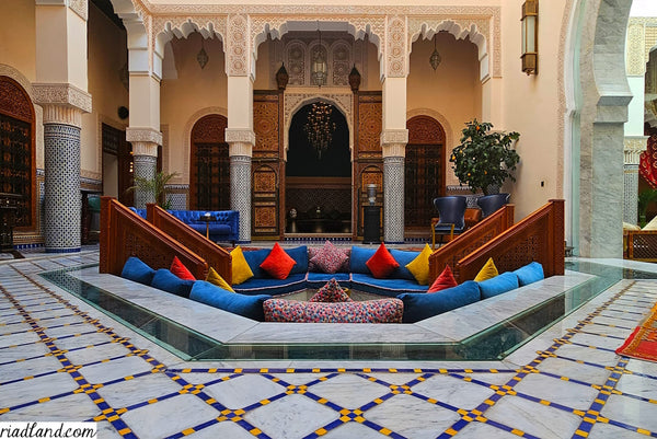 Vibrant seating area in a riad, featuring colorful pillows and traditional decor