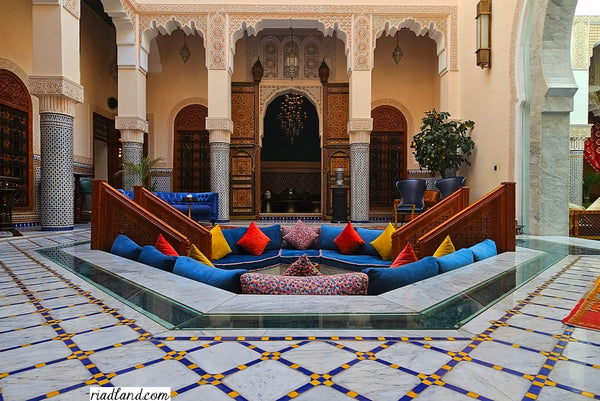 Vibrant seating area in a riad, featuring colorful pillows and traditional decor