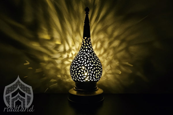 Fancy table lamp casting cool patterns on the dark wall