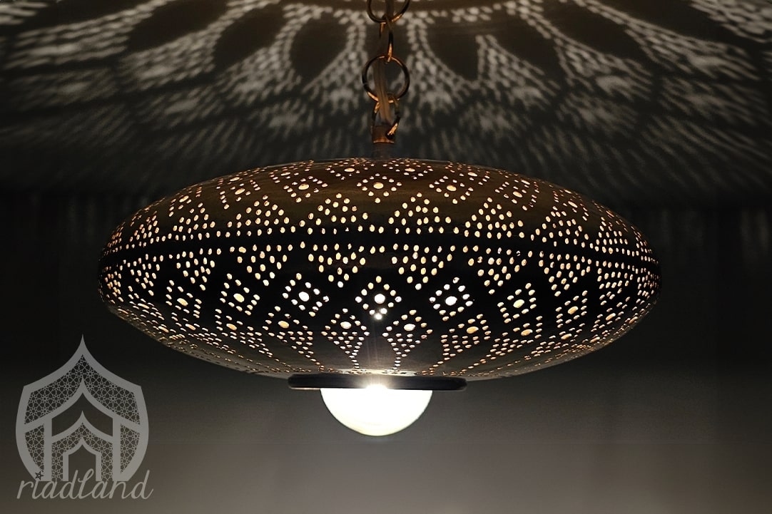 Golden hanging lamp crafted with care, showcasing beautiful patterns on the ceiling