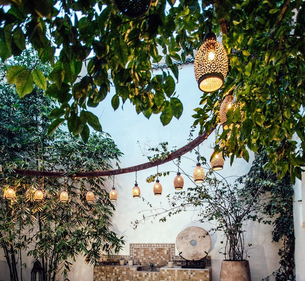 A row of golden lamps hanging in a beautiful garden.