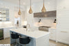 Elegant-kitchen-with-white-cabinetry-a-central-island-and-three-luxurious-golden-hanging-lamps