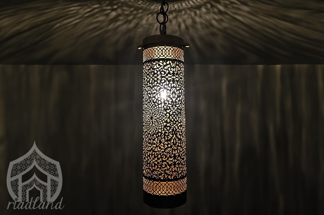 Handcrafted brass lamp with beautiful patterns shining through the darkness