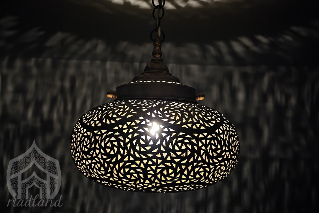 Luxury golden brass lamp in the dark with cozy patterns on the wall