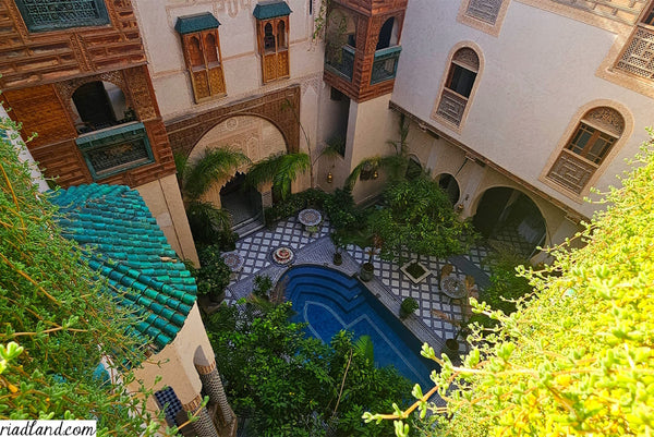 Swimming pool surrounded by plant-covered walls in a riad courtyard