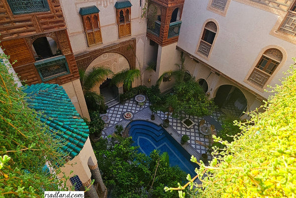 Swimming pool surrounded by plant-covered walls in a riad courtyard