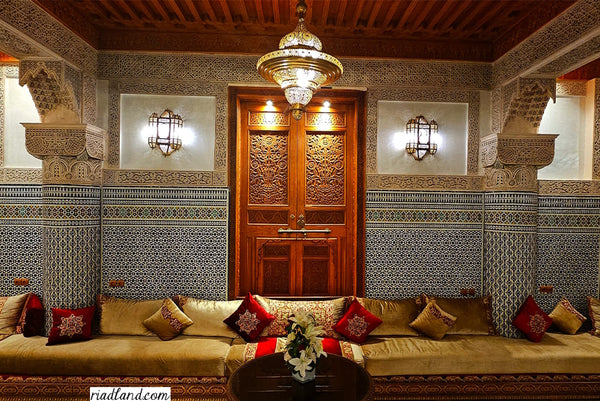 Interior of a riad featuring a traditional Moroccan sofa with authentic pillows and lamps