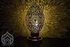 Shiny brass table lamp with pretty patterns on the wall in the dark